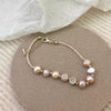 A delicate bracelet with natural freshwater pearls and strawberry quartz beads on a gold-tone chain.
