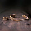 Close-up of a vintage wrapped copper wire cuff bracelet on a wrist