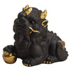 Black purple clay Pixiu tea pet with gold details holding an ingot on a tea mat