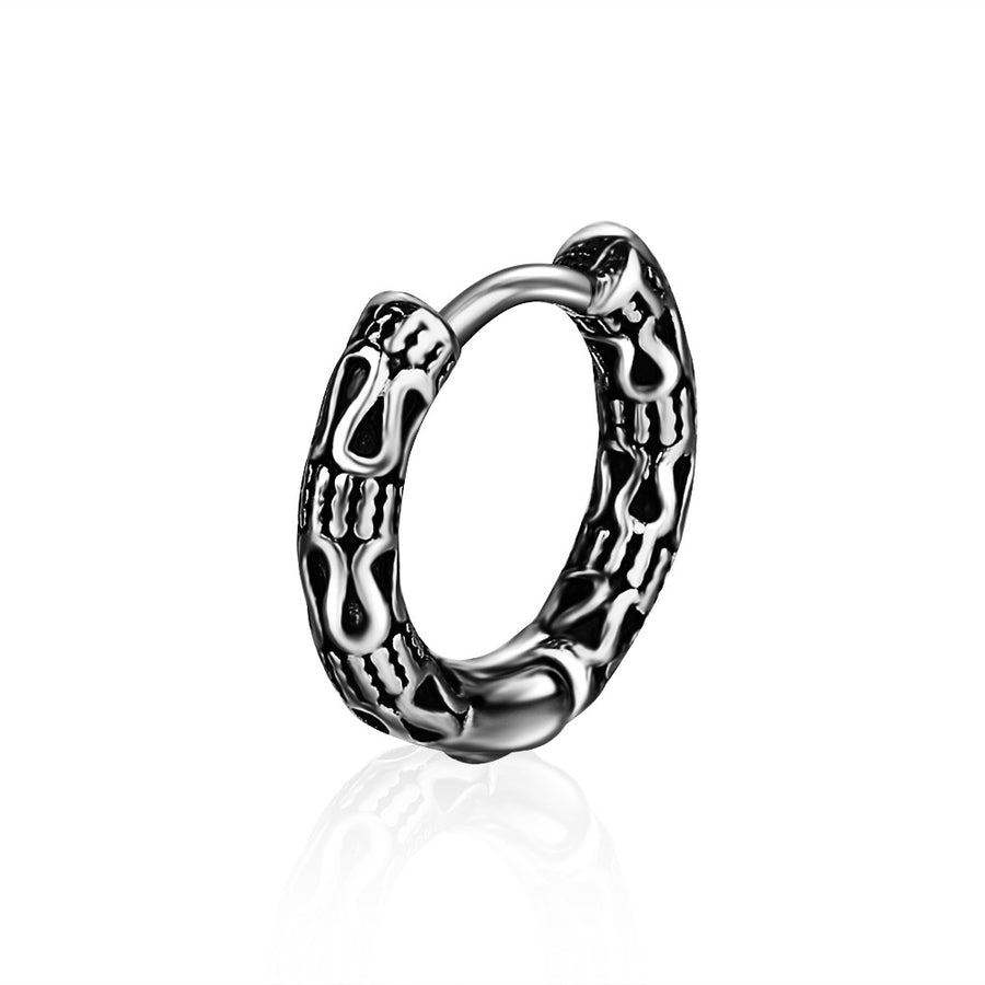 Close up of a textured titanium steel hoop earring with an antique silver finish on a white background