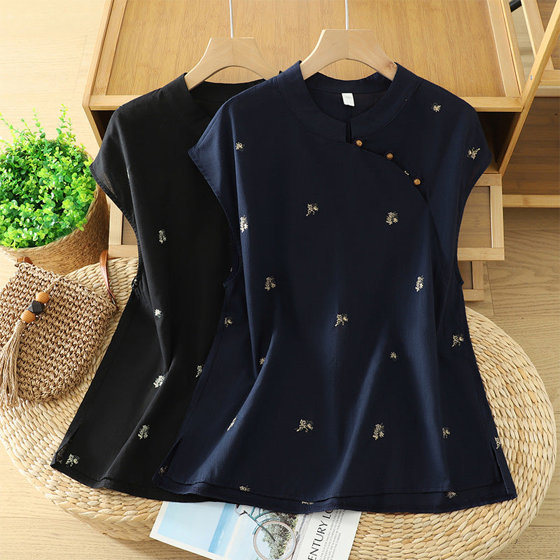 Black and navy blue embroidered cotton linen tops with mandarin collars hanging on wooden hangers