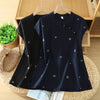 Black and navy blue embroidered cotton linen tops with mandarin collars hanging on wooden hangers