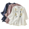 Three women's shirts in white, pink, and blue with floral embroidery and stand collars