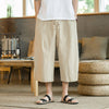Model wearing beige men's wide leg cropped linen pants with hands in pockets