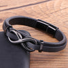 Black leather bracelet with a dark metal infinity symbol clasp on a wooden surface