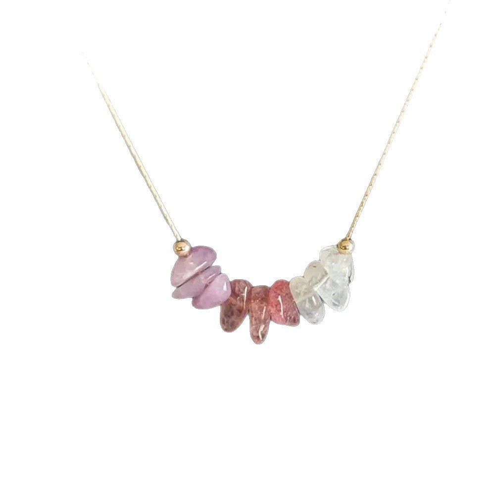 Gold tone necklace with pink and clear crystal chips on a white background