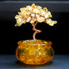 Close up of a yellow citrine crystal tree in a glass pot