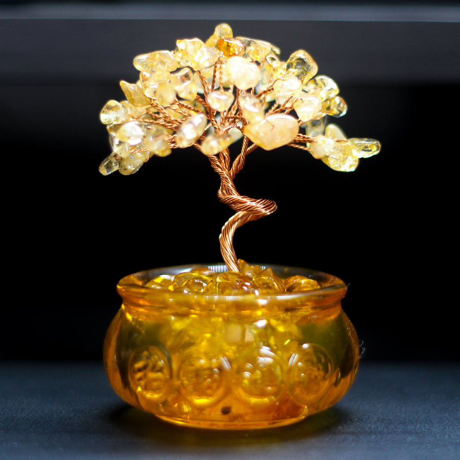 Close up of a yellow citrine crystal tree in a glass pot