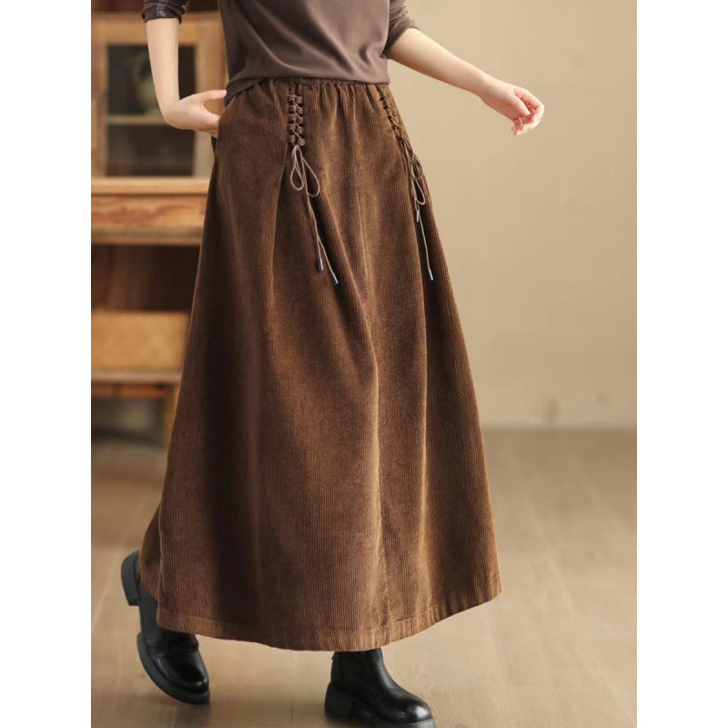 Woman wearing a brown corduroy midi skirt with hands in pockets