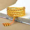Yellow and purple glass bead mala bracelets wrapped on an open book