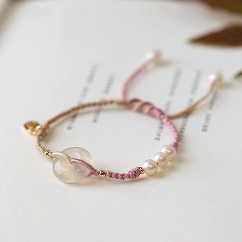 Pink braided bracelet with a white chalcedony peace buckle charm