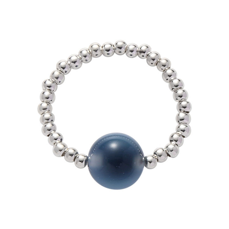 Close up of a blue agate bead ring on a finger