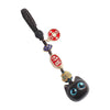 Ebony wood cat keychains with red charms lying on a book