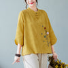 Model wearing a light green embroidered cotton-linen top with beige pants