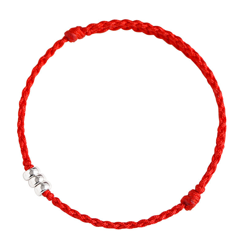 Close up view of a red braided cord bracelet with three silver beads