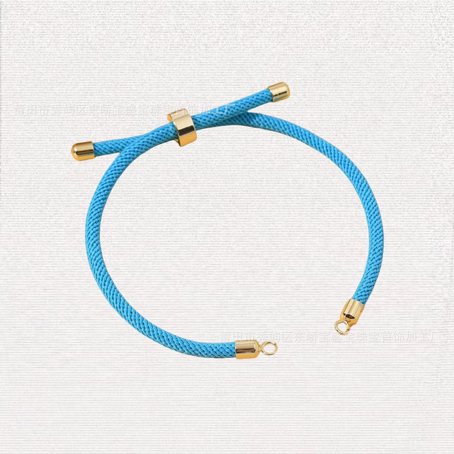 Blue woven nylon cord bracelet with gold-tone copper ends and sliding knot