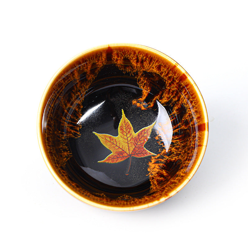 Ceramic teacup with maple leaf design and glazed finish