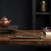 Zinc alloy incense burner shaped like a boat with a fisherman figure holding an incense stick.