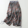 Flat lay of women's wide leg pants with a red and blue leaf pattern and drawstring hems