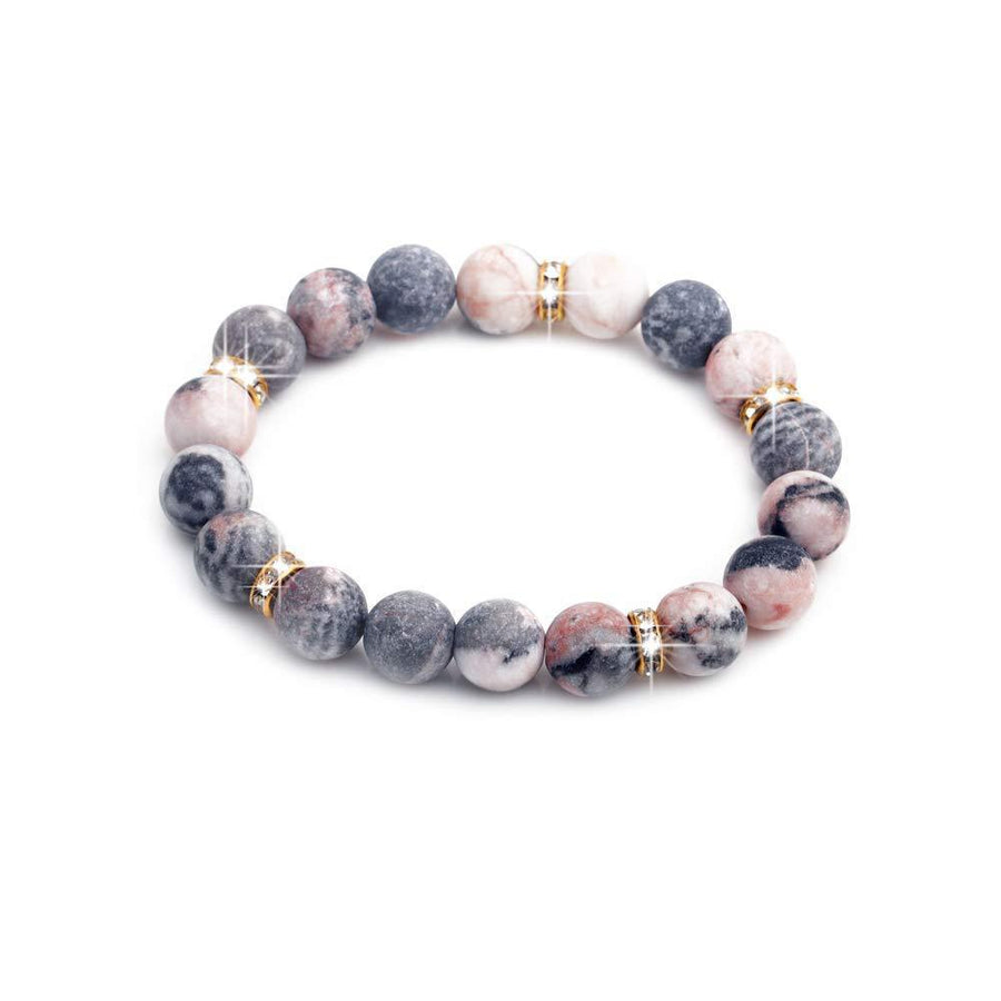 Pink and grey zebra jasper bead bracelet with gold tone crystal spacers on white background