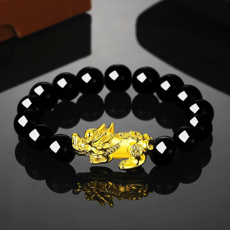 Gold tone double Pixiu charm on a black beaded stretch bracelet
