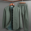 Green fleece lined men's Tang suit set with long sleeve top and pants hanging on wooden hangers