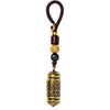 Hand holding a brass cylinder key chain with woven cord and beads