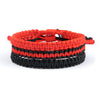 Stack of three handwoven red and black string bracelets