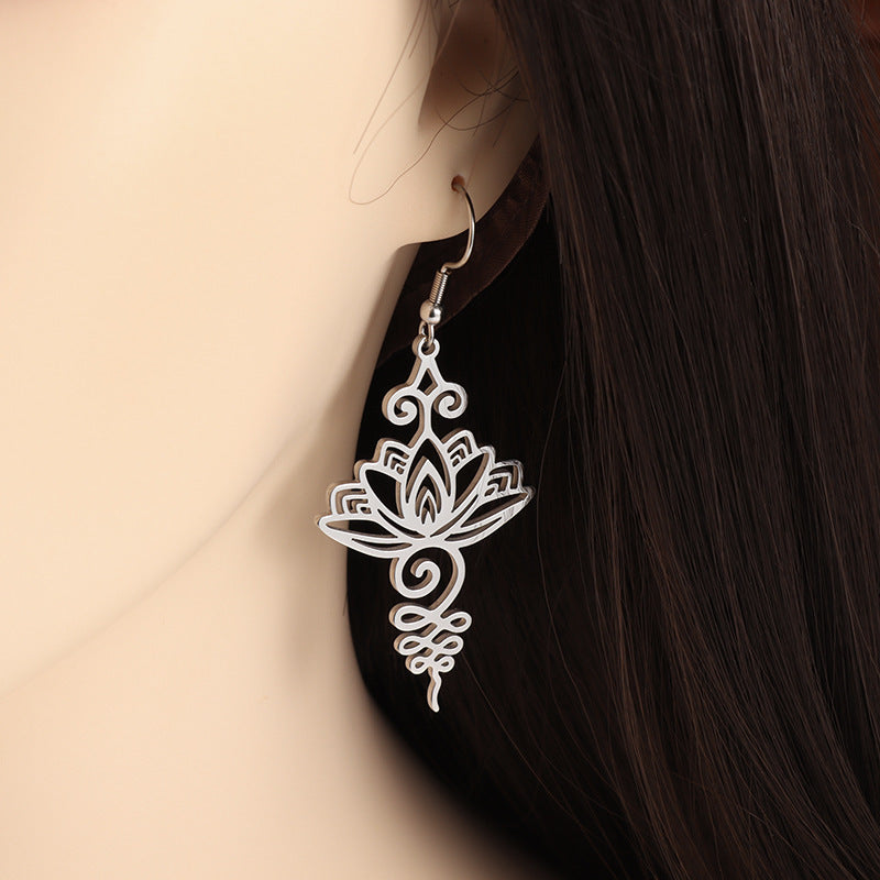 Silver-tone hollow lotus flower drop earring worn on ear