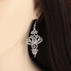 Silver-tone hollow lotus flower drop earring worn on ear