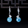 Pair of 925 sterling silver drop earrings with round blue aquamarine stones and leaf details