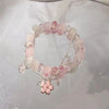 Close up of a pink beaded bracelet with a flower charm