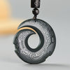 Close up of dark green carved jade pendant with silver inlay patterns