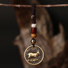 Close up of a brass keychain pendant featuring a goat or sheep design