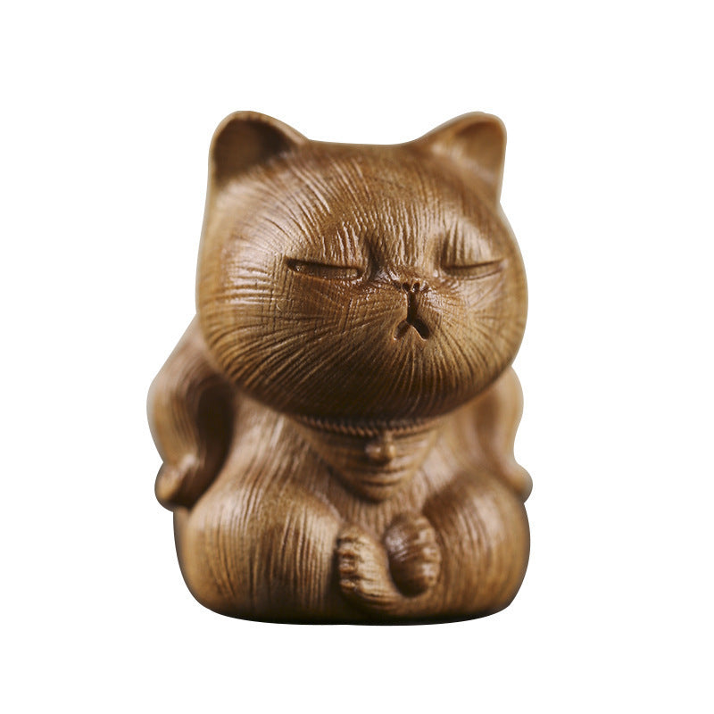 Close up view of a small carved green sandalwood cat statue sitting with paws on hips