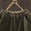 Close up of the high waist button detail on olive green corduroy pants