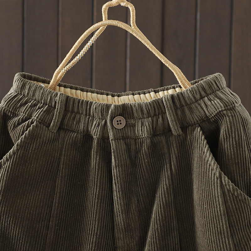 Close up of the high waist button detail on olive green corduroy pants
