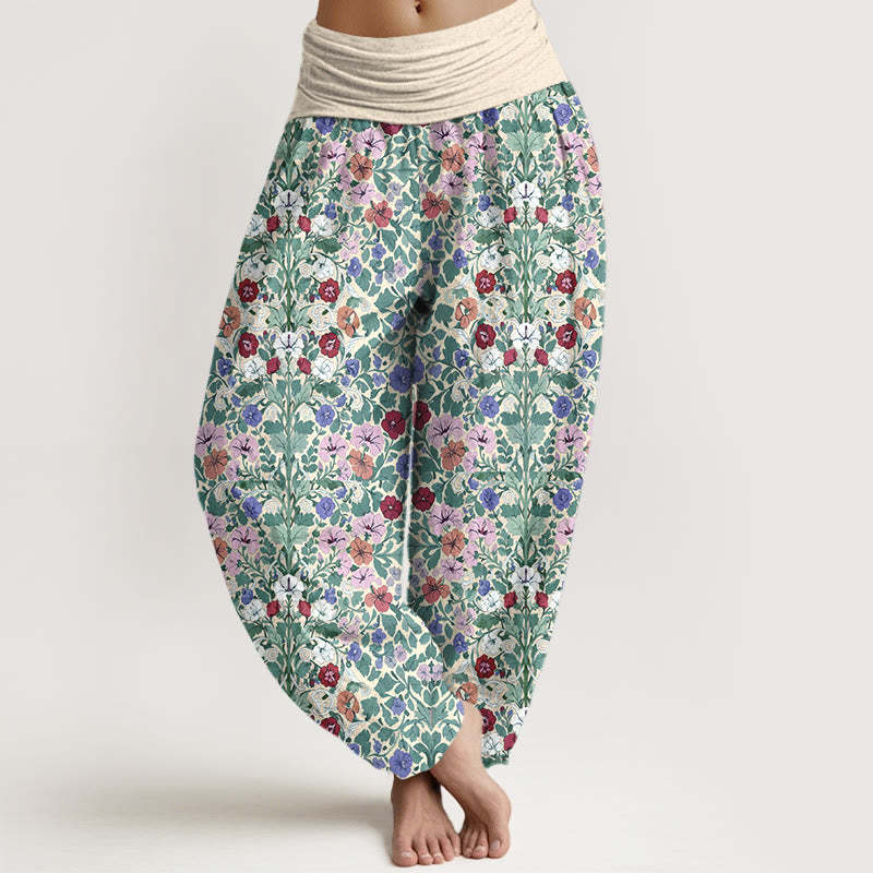 Model wearing loose fitting cotton harem pants with a green floral vine pattern