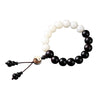 Black and white beaded bracelet with yin yang charm on a wrist