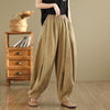 Woman wearing loose fitting beige wide leg cotton linen pants