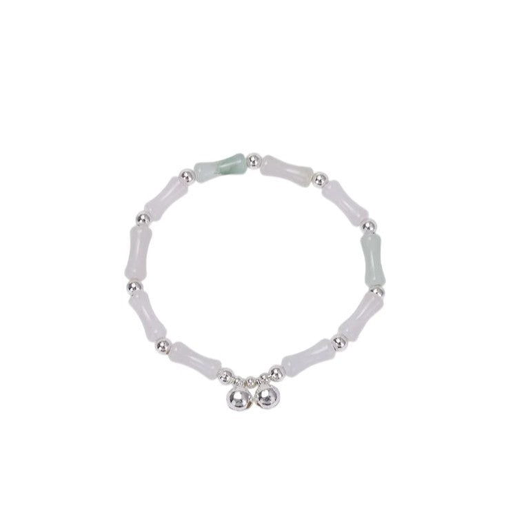 Close up of bamboo style bracelet with bells on wrist