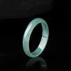 Polished natural jade ring with blue water color on black background
