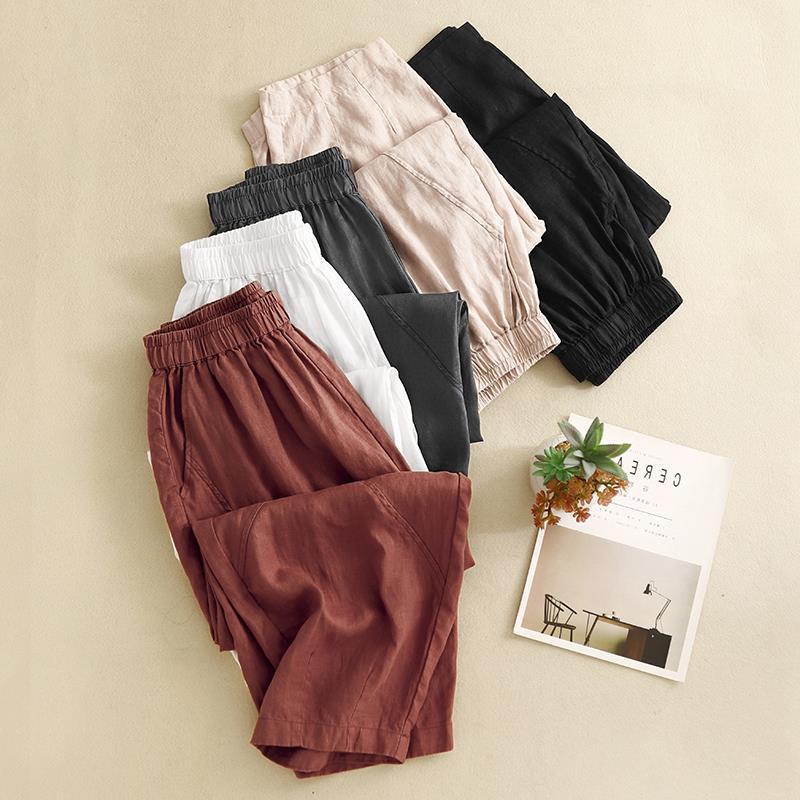 Folded stack of colorful cotton linen harem pants with elastic waists