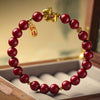 Red cinnabar bead bracelet with gold horse charm on display