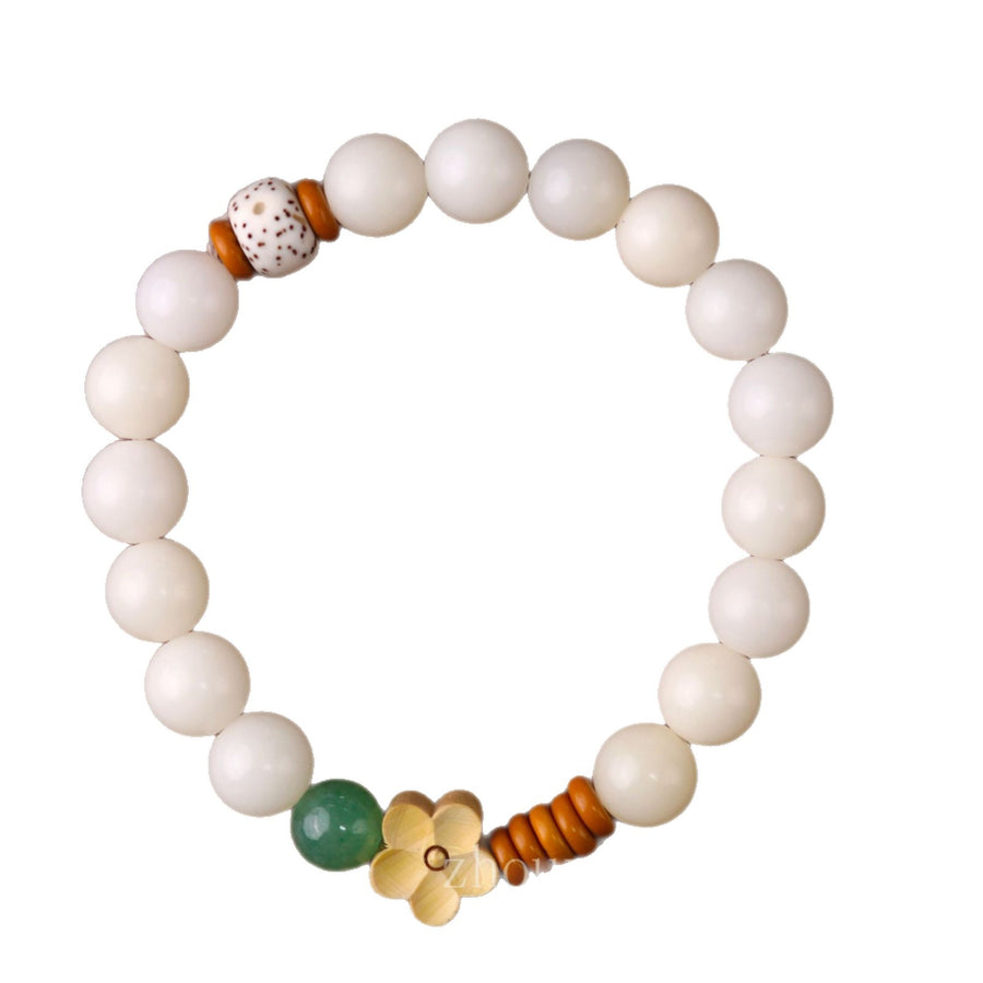 White bodhi seed bracelet with a gold lotus charm and green bead on a white background