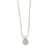 Hand holding a gold necklace with a green jade bead pendant