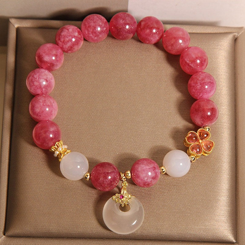 Pink tourmaline beaded bracelet with white crystal spacers and a gold-tone clover charm