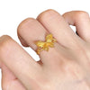 Close up of a gold tone butterfly ring on a finger