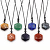 A row of hexagonal crystal pendant necklaces in various colors including tiger eye, green aventurine, and lapis lazuli.