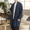 Man wearing a dark blue loose fit linen blend mid-length coat with open front